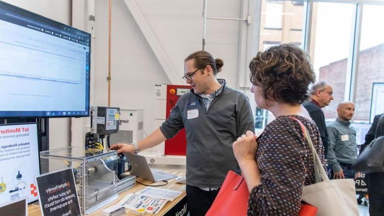 Man demonstrates technology to event attendee